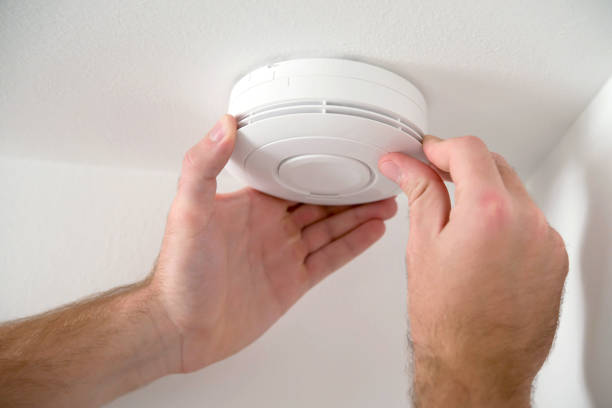 man installing smoke or carbon monoxide detector